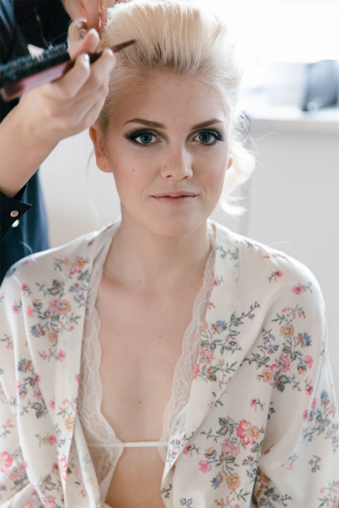 Mobile Haarstylistin steckt Hochzeitsfrisur