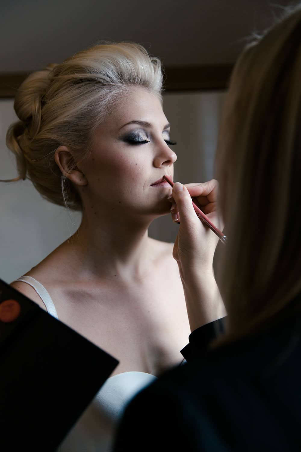 Mobile Brautstylistin schminkt Braut-Make-up während Getting-Ready