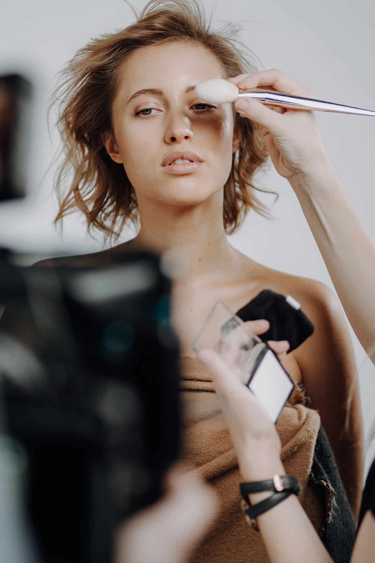 Visagistin schminkt Model für Beautyshooting