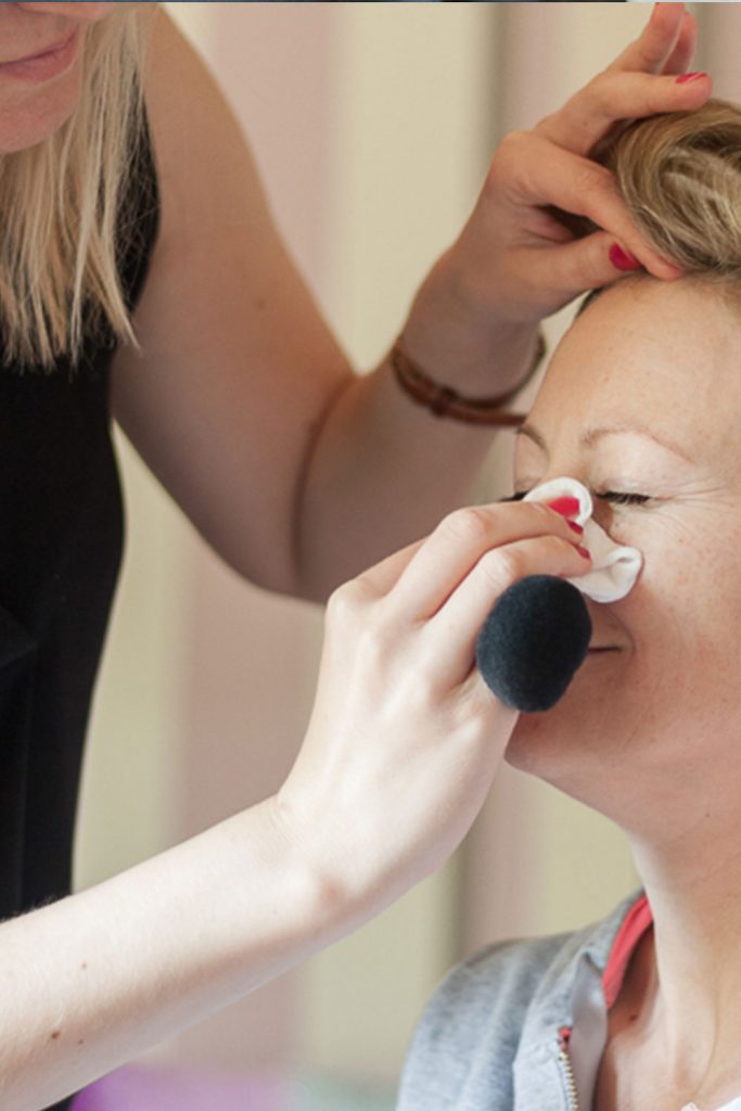 Brautstylistin schminkt Frau ab