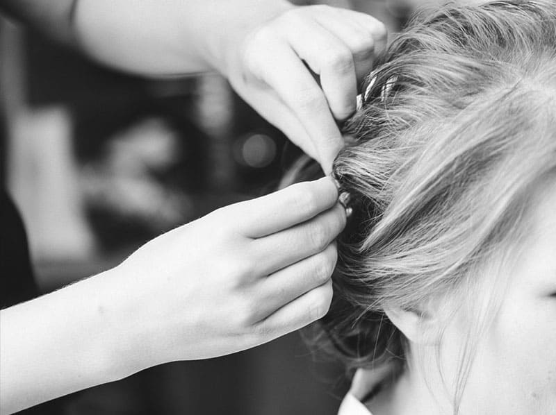 Hairstylistin steckt die Brauthaare hoch