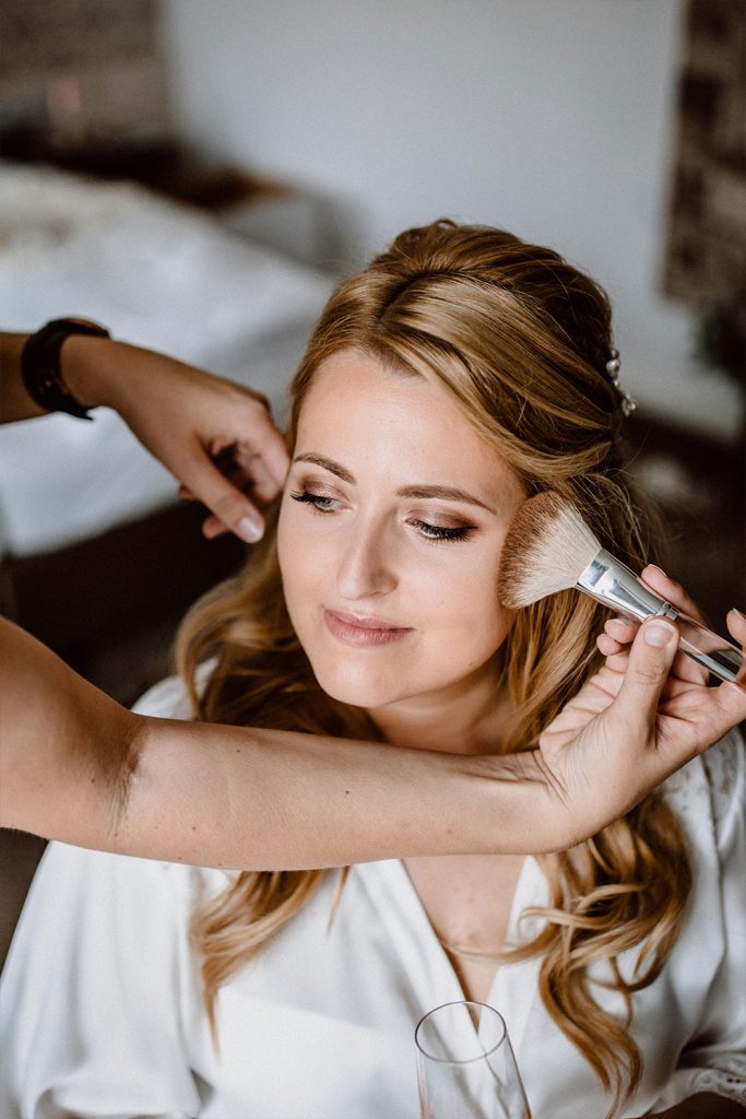 Braut genießt professionelles Make-up von Visagistin