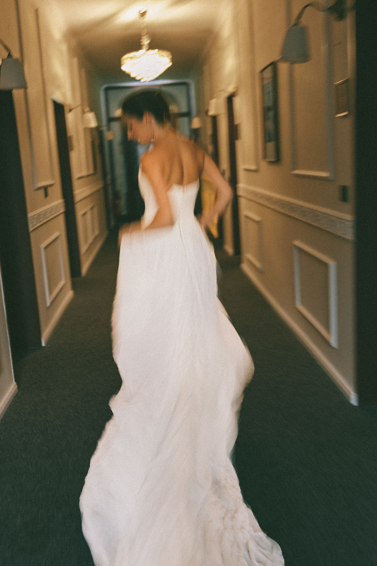 Braut im Brautkleid am späten Hochzeitstag auf dem Weg durch einen Hotelgang