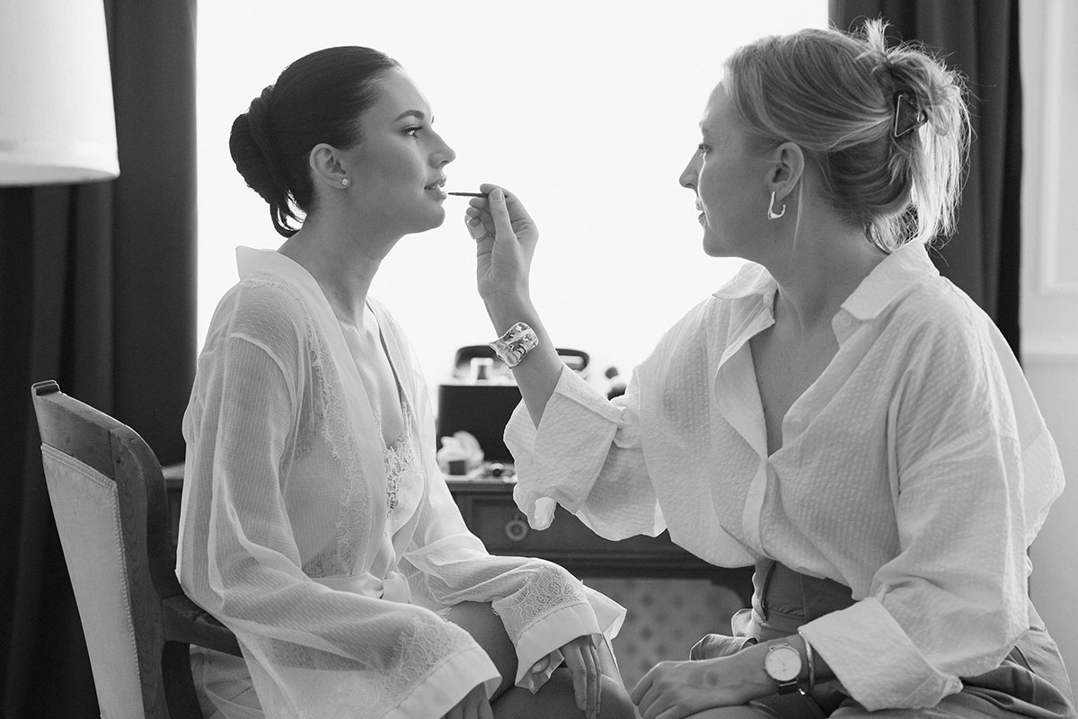 Personal moment during bridal makeup – calm, attentive guidance with sensitivity to personality and atmosphere.